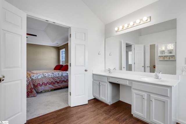 bathroom featuring vanity, wood-type flooring, and vaulted ceiling