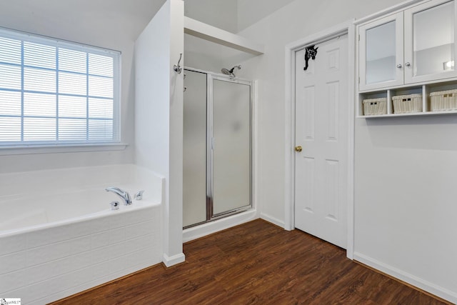 bathroom with independent shower and bath and hardwood / wood-style flooring