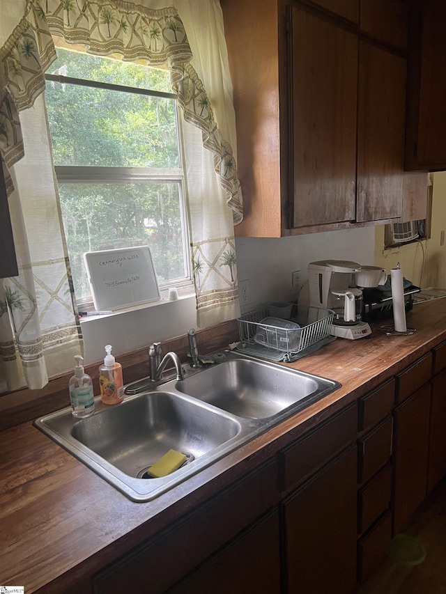 kitchen with sink, dark brown cabinets, and wooden counters