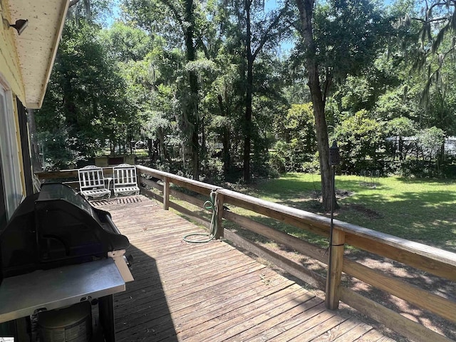 wooden deck featuring a lawn