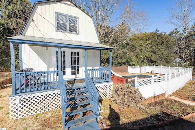 rear view of house featuring a pool side deck and french doors