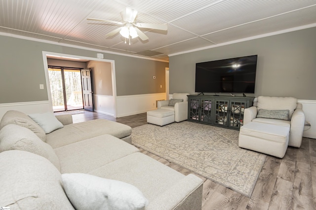 living room featuring ceiling fan, wood-type flooring, and ornamental molding