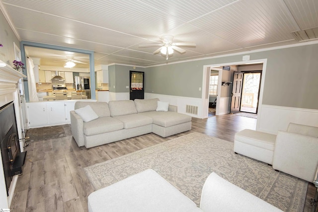 living room featuring ceiling fan, light hardwood / wood-style flooring, and ornamental molding