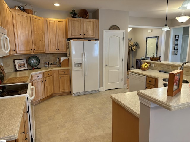 kitchen with tasteful backsplash, sink, white appliances, hanging light fixtures, and a kitchen island with sink