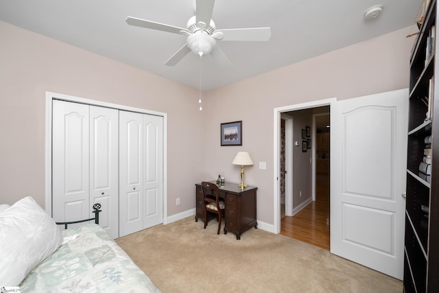 bedroom featuring ceiling fan, a closet, and light carpet