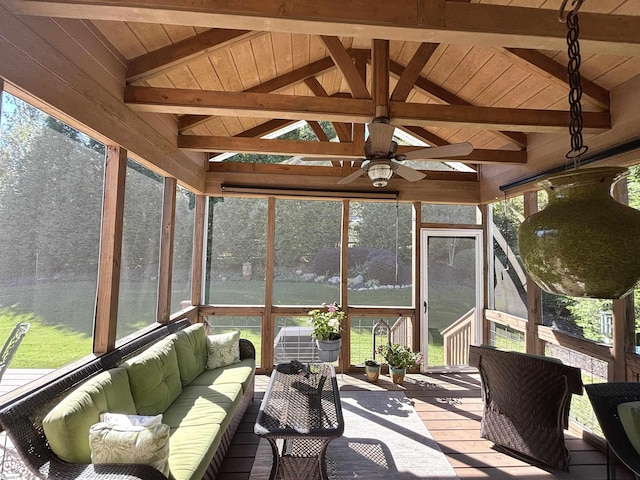 sunroom with ceiling fan, lofted ceiling with beams, a wealth of natural light, and wooden ceiling