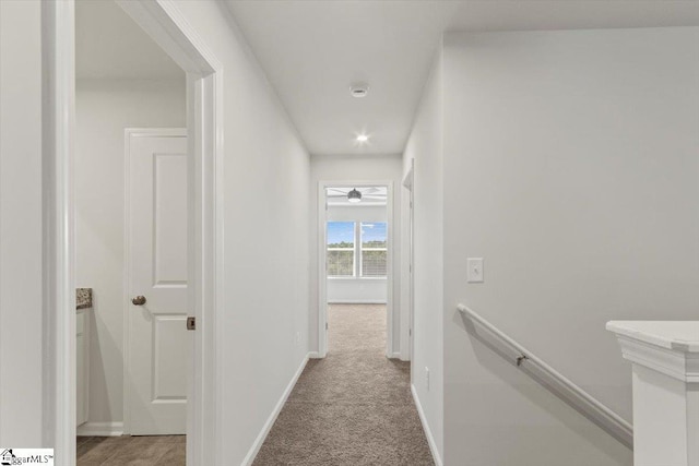 hallway featuring light colored carpet