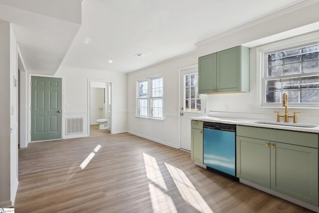 kitchen with green cabinets, light hardwood / wood-style floors, dishwasher, and sink