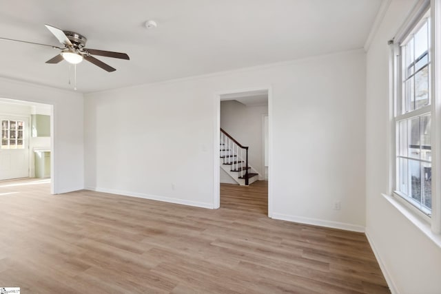 spare room featuring ceiling fan, ornamental molding, and light wood-type flooring