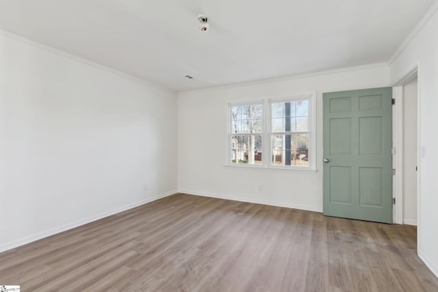 unfurnished room with ornamental molding and light wood-type flooring