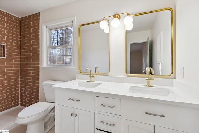 bathroom with toilet, vanity, and tiled shower