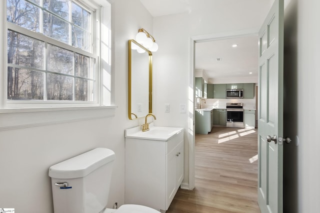 bathroom featuring toilet, vanity, and hardwood / wood-style flooring