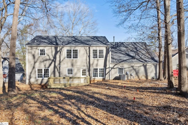 back of property with a deck and central AC