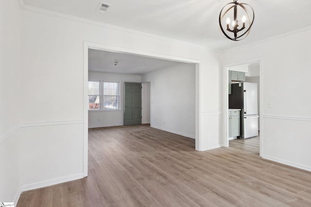 spare room with a chandelier, light hardwood / wood-style floors, and ornamental molding