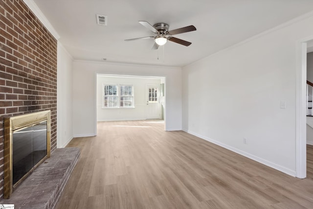 unfurnished living room with ceiling fan, ornamental molding, a fireplace, and light hardwood / wood-style flooring