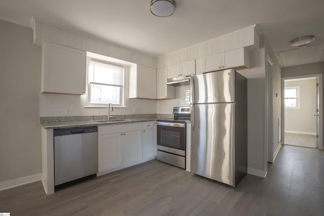 kitchen with sink, white cabinetry, appliances with stainless steel finishes, and hardwood / wood-style floors