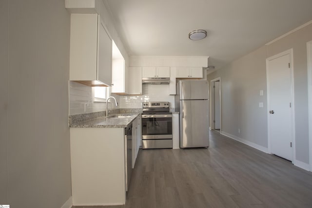 kitchen featuring tasteful backsplash, sink, white cabinetry, light stone countertops, and stainless steel appliances