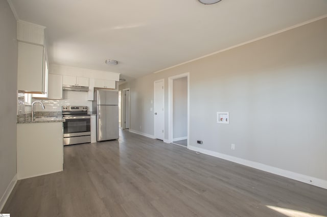 kitchen with white cabinets, appliances with stainless steel finishes, wood-type flooring, tasteful backsplash, and sink