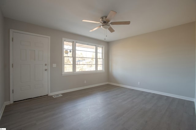 unfurnished room with ceiling fan and dark wood-type flooring