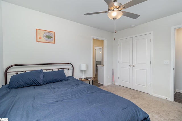 carpeted bedroom featuring ceiling fan and a closet