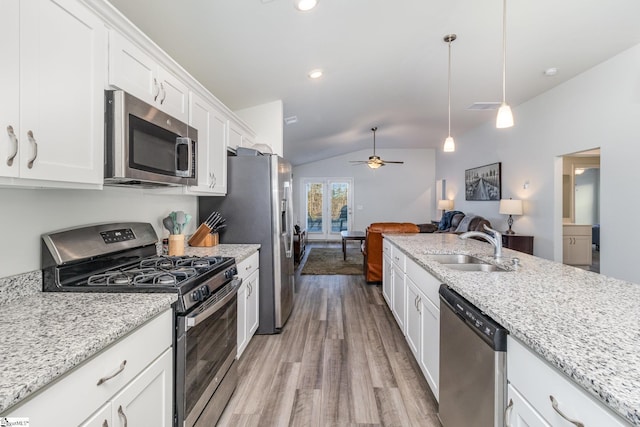 kitchen with ceiling fan, stainless steel appliances, lofted ceiling, hanging light fixtures, and white cabinets