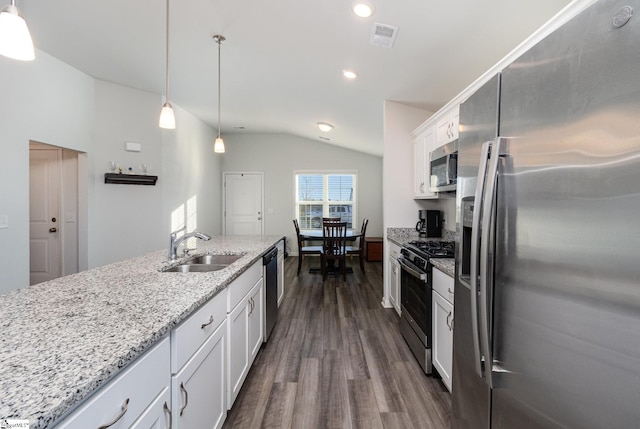 kitchen featuring appliances with stainless steel finishes, dark hardwood / wood-style floors, vaulted ceiling, pendant lighting, and white cabinets