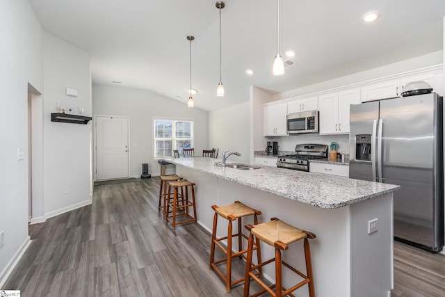 kitchen with appliances with stainless steel finishes, white cabinets, and a kitchen island with sink