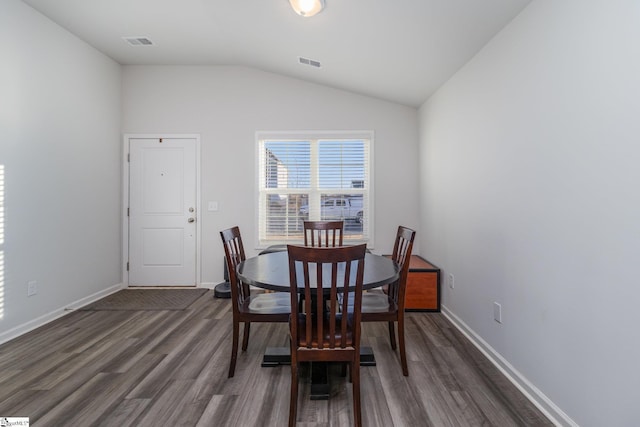 dining room featuring lofted ceiling and dark wood-type flooring