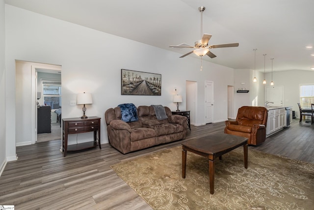 living room with ceiling fan, hardwood / wood-style floors, and vaulted ceiling