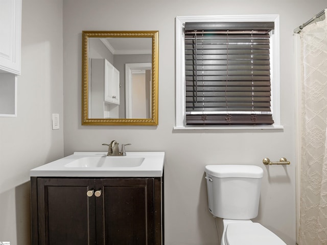 bathroom with vanity, crown molding, and toilet