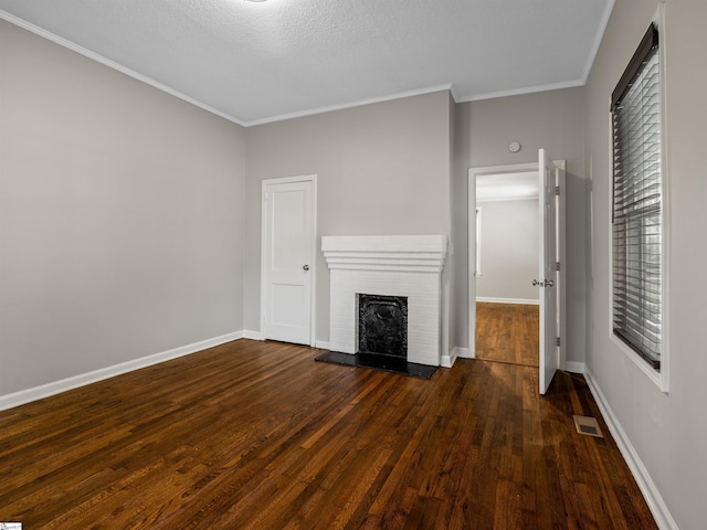 unfurnished living room with crown molding, a brick fireplace, dark hardwood / wood-style floors, and a textured ceiling