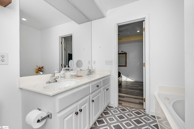 bathroom featuring vanity, tile patterned floors, and a bath