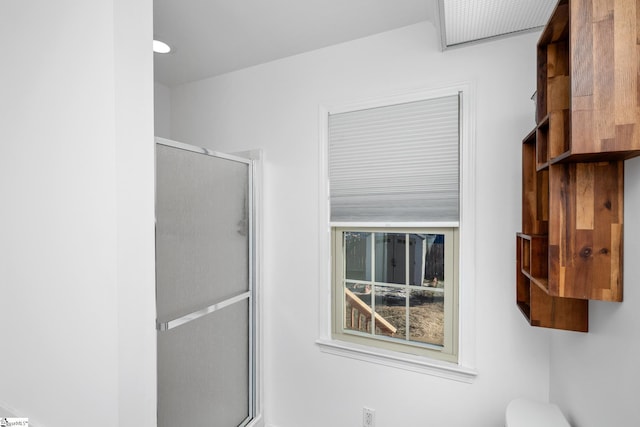 bathroom with toilet and a shower with shower door