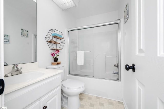 full bathroom with enclosed tub / shower combo, vanity, and toilet