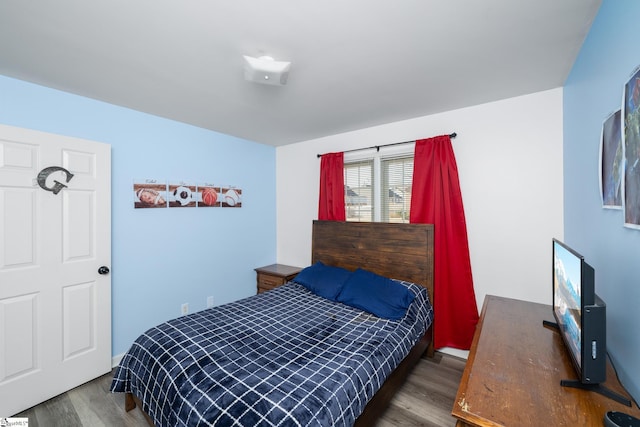 bedroom with dark hardwood / wood-style floors