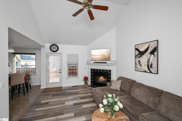 living room featuring ceiling fan, dark hardwood / wood-style floors, high vaulted ceiling, and a fireplace