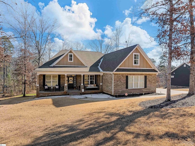 craftsman-style home featuring covered porch and a front yard