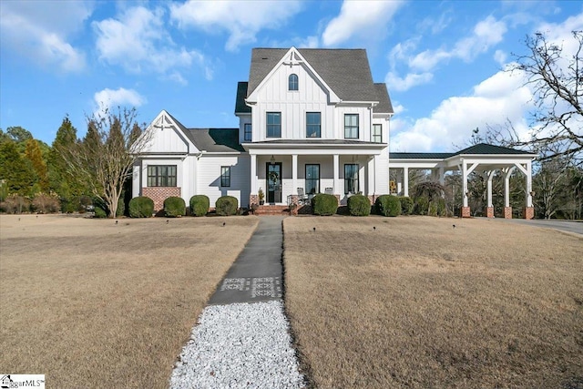 modern farmhouse with a carport, covered porch, and a front yard