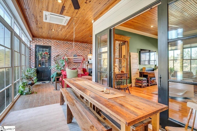 sunroom with ceiling fan and wooden ceiling