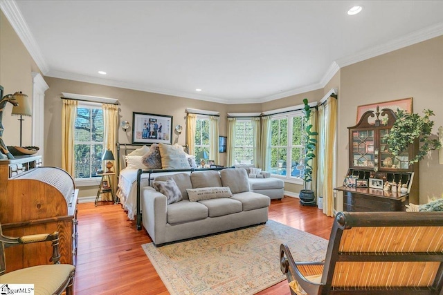 living room featuring wood-type flooring, a wealth of natural light, and ornamental molding