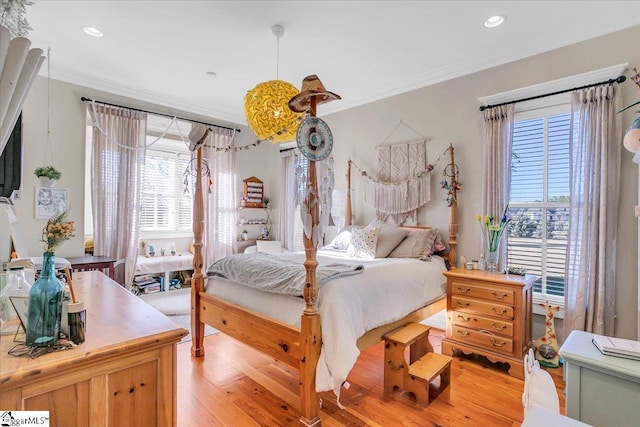 bedroom with crown molding and light hardwood / wood-style flooring