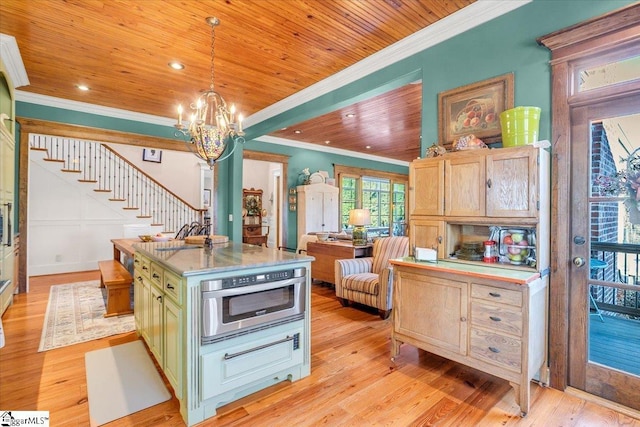 kitchen with a center island, light hardwood / wood-style floors, hanging light fixtures, a chandelier, and crown molding