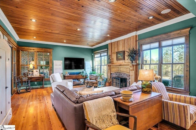 living room with a brick fireplace, crown molding, and light hardwood / wood-style flooring