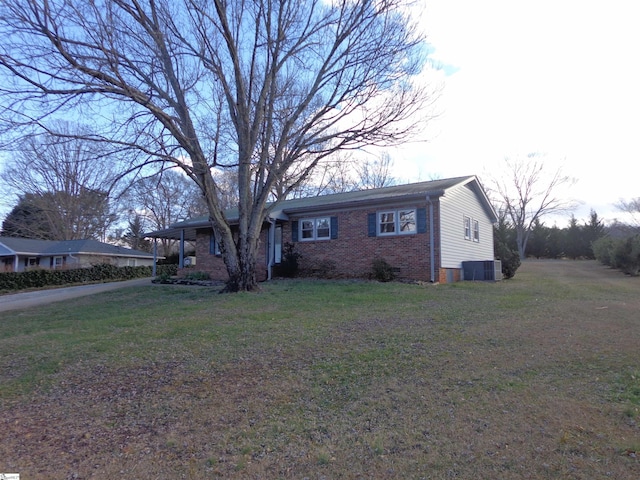 ranch-style home featuring a front lawn and cooling unit