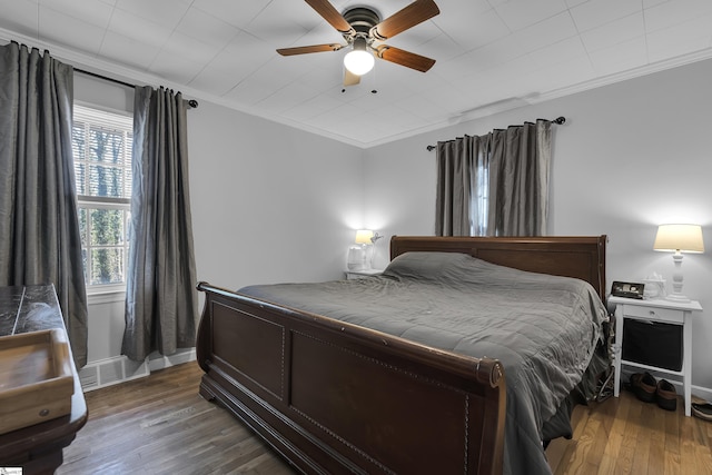 bedroom featuring ceiling fan, dark hardwood / wood-style floors, and ornamental molding