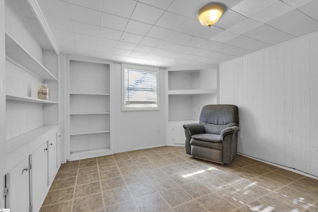 sitting room with built in features and wooden walls