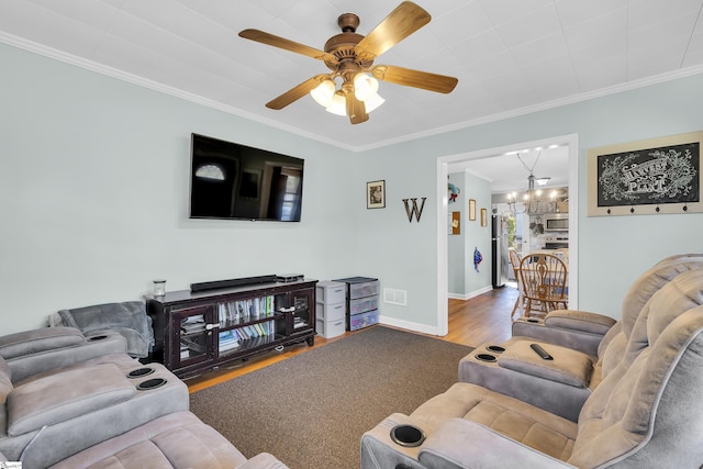 living room featuring ceiling fan with notable chandelier, wood-type flooring, and crown molding