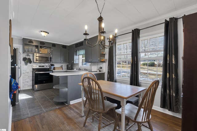 dining room featuring dark wood-type flooring, a chandelier, and crown molding