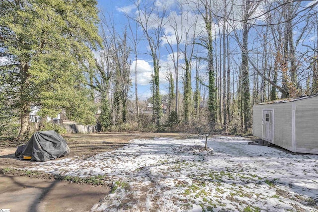 yard layered in snow with a storage shed