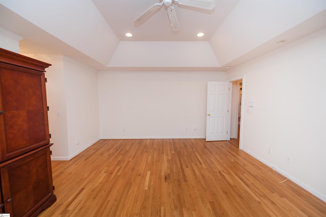 unfurnished room with light hardwood / wood-style flooring, a raised ceiling, and ceiling fan